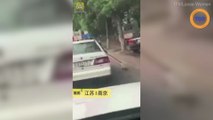 Scandaleux : ces policiers chinois trainent un chien à côté de leur voiture