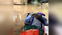 Man pushes belongings on kayak in flooded France campsite