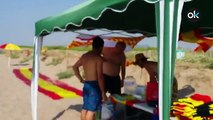 Llenan la playa del Prat de sombrillas con la bandera española