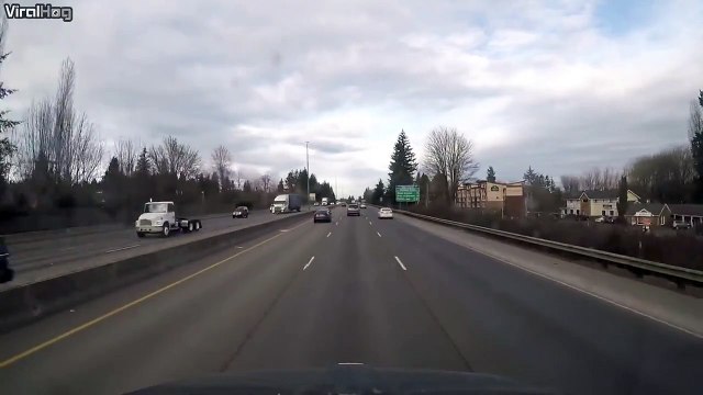 Ce motard fini accroché sur le coffre d'une voiture