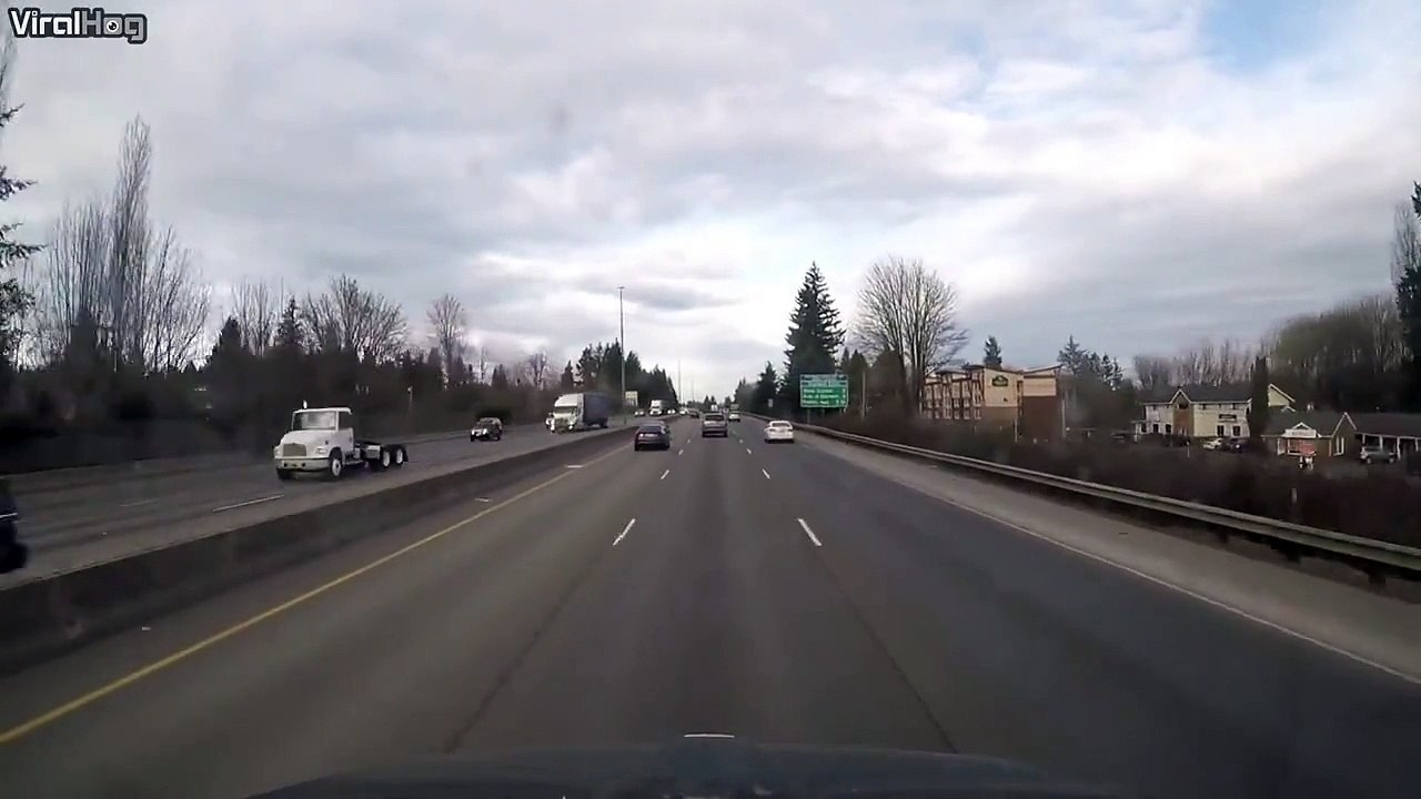 Ce motard fini accroché sur le coffre d'une voiture