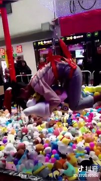 Des japonais jouent aux pinces de la fête foraine avec un harnais