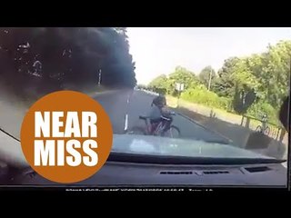 Boy cyclist nearly being run over while crossing busy road