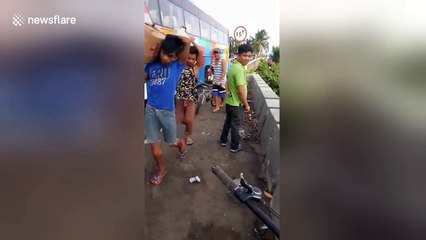 Frantic locals grab hundreds of bottles of brandy after lorry spilled its load