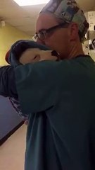 Veterinário embala cadela como uma criança para que fique calma após cirurgia