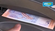 Venezuelans withdraw their first new banknotes from ATMs