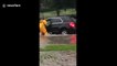 Firefighter rescues driver as fast-moving floodwaters carry vehicle away