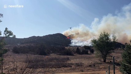 Helicopter conducts water drop on brush fire in Riverside County