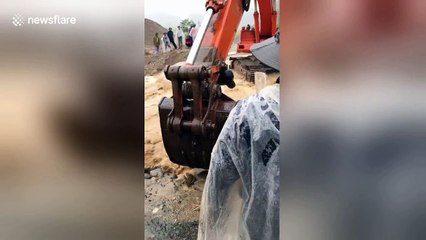 Rescuers use excavator to help villagers over flooded river
