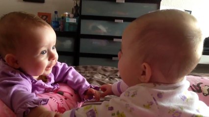 Twin babies talk and hold hands for the first time