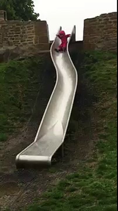Baby goes down slide and lands in puddle