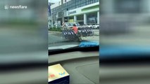 Scooter rider carries 16 bikes on shoulder while driving down road
