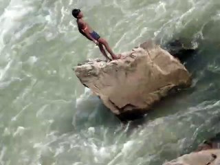 Un enfant plonge dans une rivière en crue.