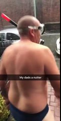 Dad stands under overflowing gutter wearing just swimming trunks and a snorkel
