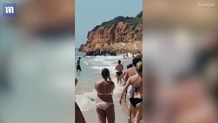 Moment migrants reach a packed tourist beach in broad