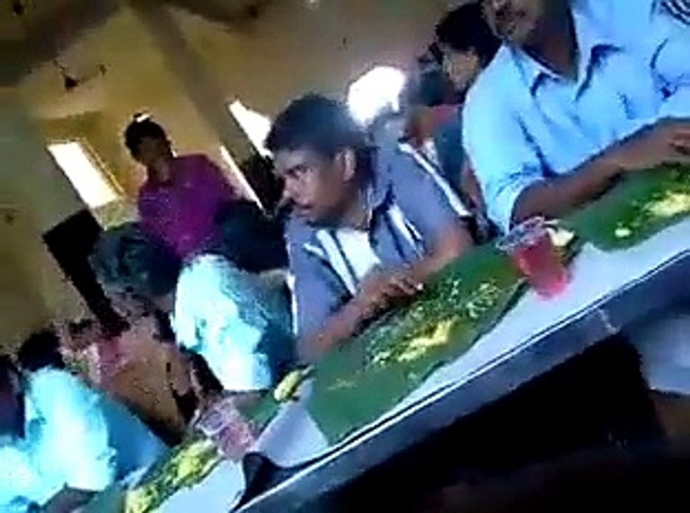 ONE MAN TAKING FOOD FROM MAN SITTING NEXT TO HIM LOL