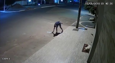 Un homme couvre un chien dans une rue