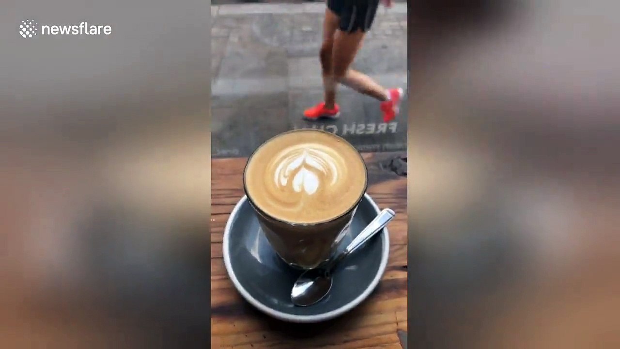 Bare-chested man reclines on chair with drink in middle of London street