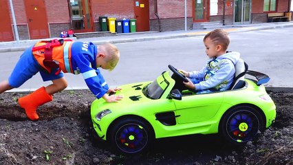 Nikita ride on children's car and stuck in the ground Vlad tows on the tractor