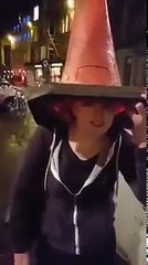 girl with a cone on her head falls over