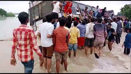 Locals rescue passengers from bus stuck on flooded bridge
