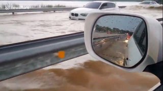 Cars struggle through flooded road in the Philippines