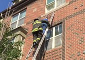 Firefighters Helps Elderly Woman Down a Ladder as Fire Rages