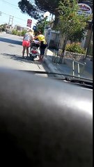 Une fille blonde croit qu’un scooter se démarre en appuyant sur la béquille