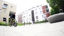 BMX biker rides down walls, over bins and benches