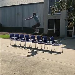 Un homme saute par-dessus 8 chaises