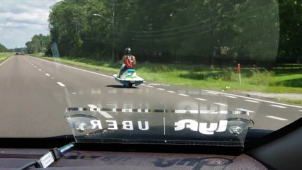 Hombre circula por la carretera con una moto acuática