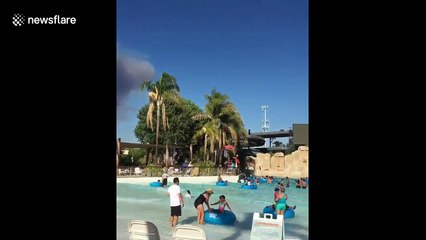 Huge pyrocumulus cloud from Charlie Fire looms above pool-splashing families at Six Flags