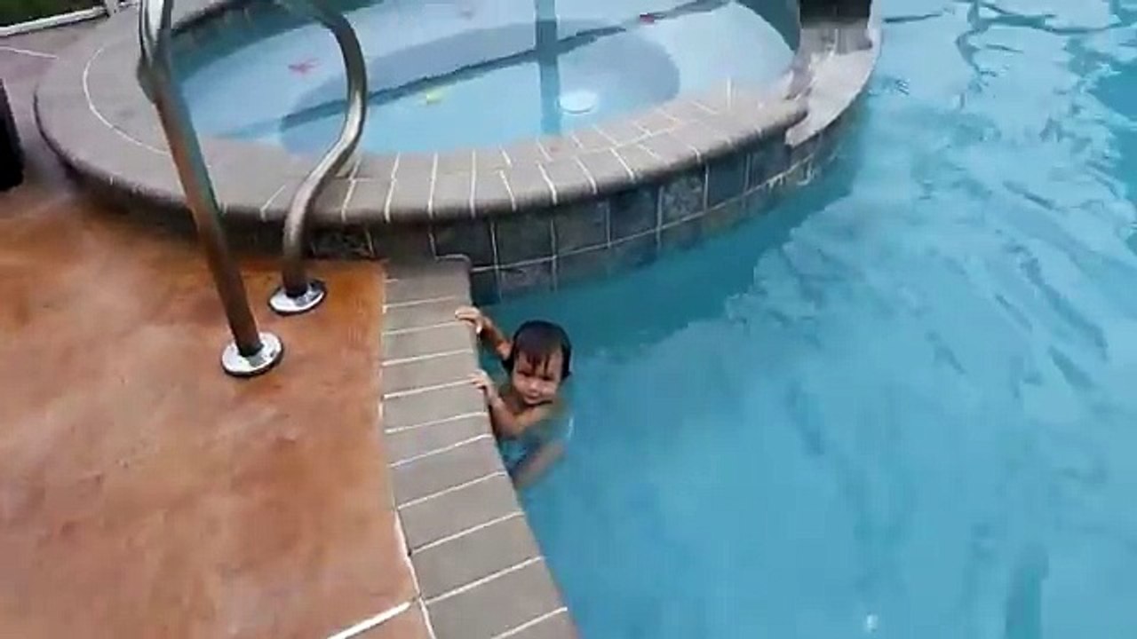 Un enfant âgé d'un an nage dans une piscine