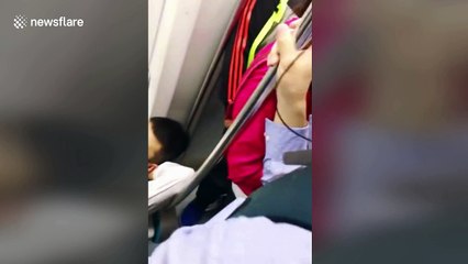 Lazy Chinese man lies across subway seats during peak time