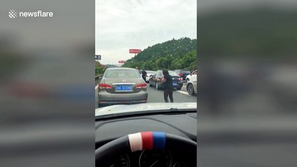 Woman gets out of car in highway gridlock to do Tai Chi