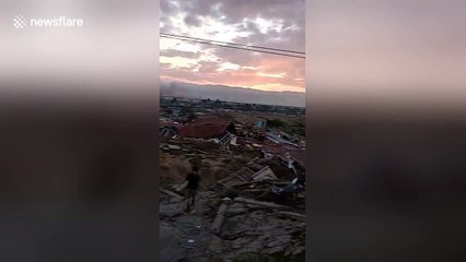 Palu residents stare at still-smoking ruins morning after magnitude 7.4 earthquake in Indonesia