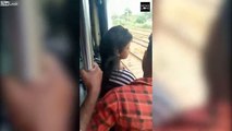 Elle manque de tomber du train en se pendant par la porte ouverte !