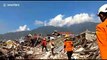 Rescuers walk through piles of rubble in aftermath of deadly Indonesia earthquake