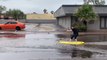 Man Surfs Along Flooded Street in Casa Grande, Arizona