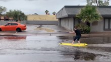 Man Surfs Along Flooded Street in Casa Grande, Arizona