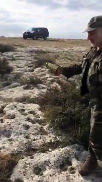 Un homme tente de jeter une canette en haut d'une falaise en Russie