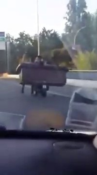 En scooter sur le périphérique parisien, il transporte un canapé avec 2 amis assis dessus