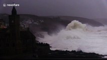 Huge swells and crashing waves in Cornwall as villagers look on