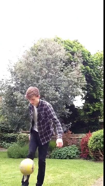 playing keepy-uppy punches the football and it rebounds in his face