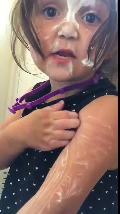 Three year old girl covered in sun tan lotion says that she hasn't touched it