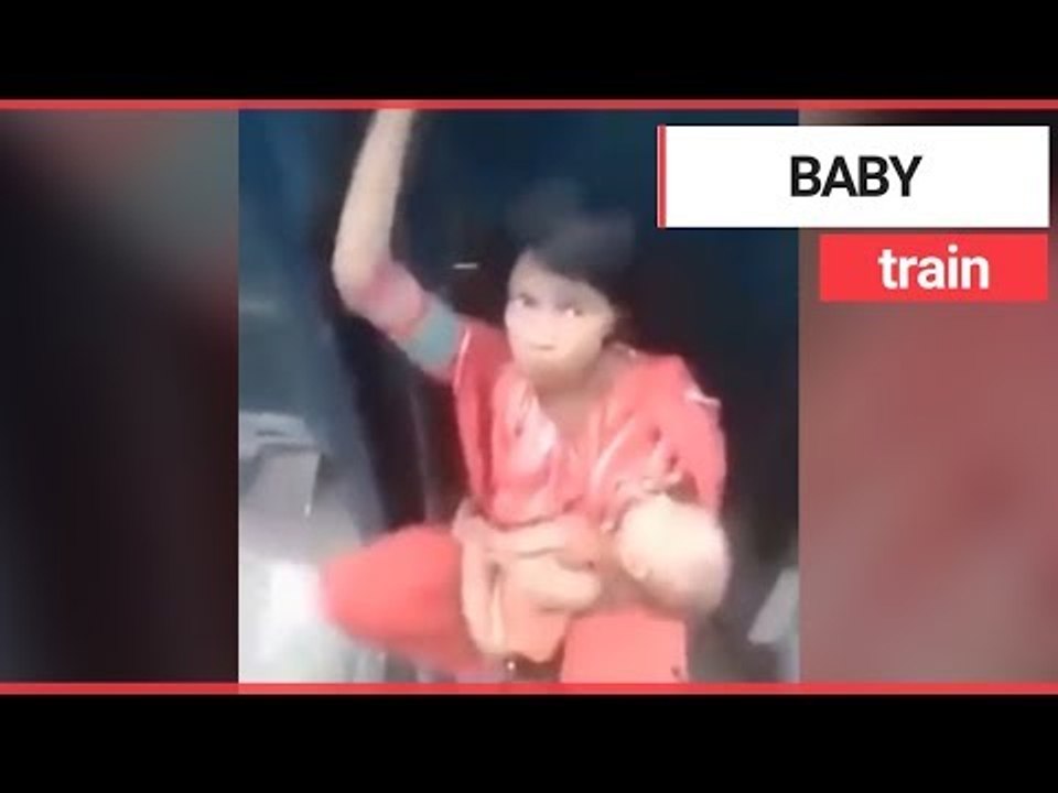 Mum cradles baby while sat between two speeding train carriages | SWNS TV