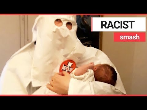 Dad pictured holding his baby dressed in Ku Klux Klan robes | SWNS TV