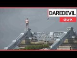 Drunk man scales 150ft bridge to escape police | SWNS TV