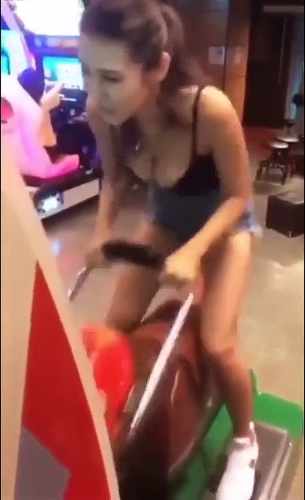 Une jeune femme s'éclate sur ce jeu dans cette salle d'arcade