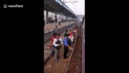 Commuters in Mumbai board packed rush-hour train from the wrong side